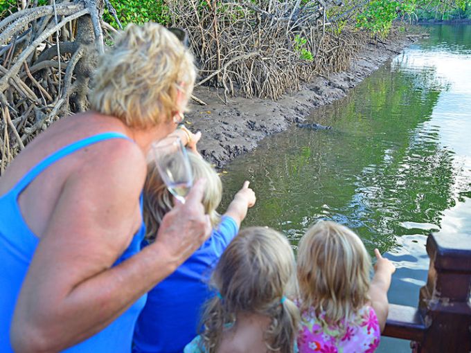 a girl drinking out of a body of water