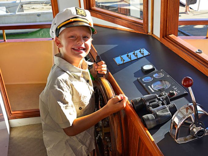 a young boy sitting at a table in front of a window