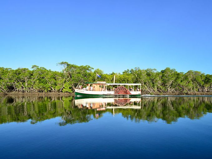 a small boat in a body of water surrounded by trees